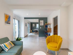 a living room with a couch and a yellow chair at Holiday Home Villa Lanka by Interhome in Arzon