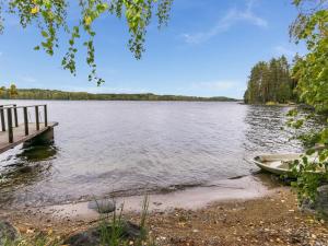a dock on a lake with a boat on the shore at Holiday Home Vihreä mökki by Interhome in Kesälahti