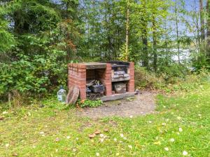 un horno de ladrillo sentado en un campo en el césped en Holiday Home Vihreä mökki by Interhome, en Kesälahti