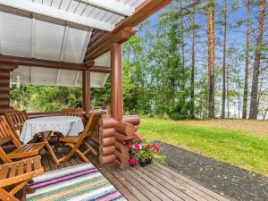 patio ze stołem i krzesłami na drewnianym tarasie w obiekcie Holiday Home Vihreä mökki by Interhome w mieście Kesälahti