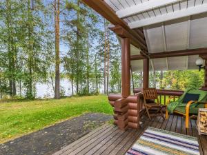 une terrasse couverte avec une table et des chaises et une vue sur le lac. dans l'établissement Holiday Home Vihreä mökki by Interhome, à Kesälahti