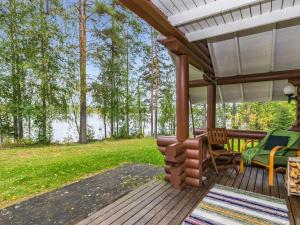 un porche avec une table et des chaises et une vue sur un lac dans l'établissement Holiday Home Vihreä mökki by Interhome, à Kesälahti