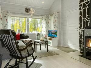 a living room with a chair and a fireplace at Holiday Home Lapinvouti by Interhome in Sirkka