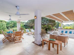 a patio with a table and chairs and a couch at Holiday Home Capichera by Interhome in Aglientu