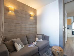 un soggiorno con divano e parete in legno di Apartment Rond Point des Pistes - Val Claret-17 by Interhome a Tignes