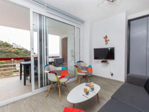 een woonkamer met een bank, stoelen en een tafel bij Apartment Rojo by Interhome in Tossa de Mar