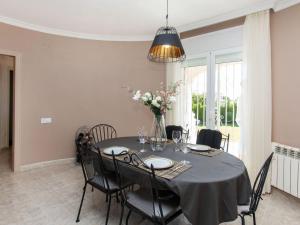 a dining room with a black table and chairs at Villa Villa Mys by Interhome in Miami Platja