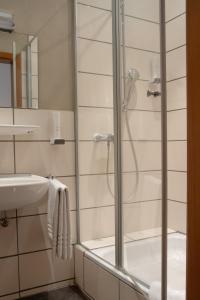 y baño con ducha y lavamanos. en Hotel Bastei, en Altmühldorf