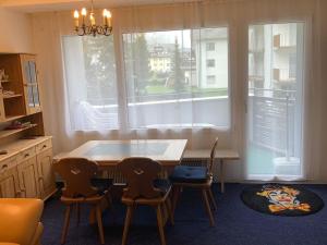 eine Küche mit einem Tisch und Stühlen sowie einem Fenster in der Unterkunft Apartment Sunnmatt 128 by Interhome in Engelberg