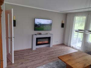 ein Wohnzimmer mit einem Kamin und einem TV an der Wand in der Unterkunft Apartment Erlenrain Wohnung 911 by Interhome in Engelberg