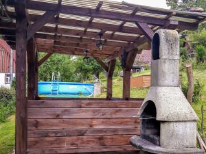 a wooden pergola with an outdoor oven in a yard at Studio Chlívce u Hronova-1 by Interhome in Chlívce