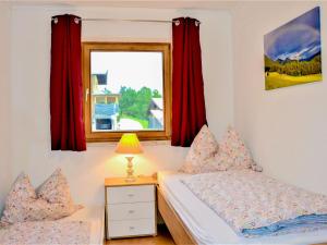um quarto com uma cama e uma janela com cortinas vermelhas em Apartment Ferienwohnung Wiesenhof by Interhome em Reith bei Seefeld