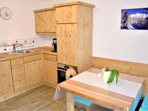 a kitchen with wooden cabinets and a table with a plant on it at Apartment Ferienwohnung Wiesenhof by Interhome in Reith bei Seefeld