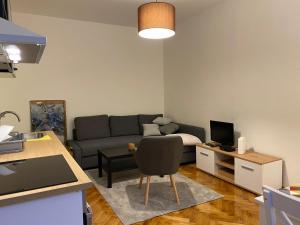 uma sala de estar com um sofá e uma mesa em Apartment Major em Belgrado