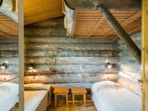 zwei Betten in einem Zimmer mit Holzwänden in der Unterkunft Holiday Home Vilkkuna 20 a by Interhome in Syöte
