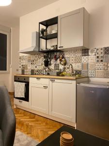 a kitchen with white cabinets and a stove top oven at Apartment Major in Belgrade