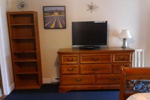 a bedroom with a dresser with a television on it at Sea Turn Motel in York