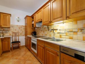 a kitchen with wooden cabinets and a sink at Holiday Home Tamas by Interhome in Balatonőszöd