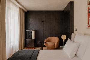 een slaapkamer met een wit bed en een stoel bij Warszauer Hotel in Krakau