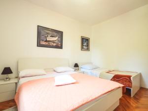 two beds in a room with white walls and wood floors at Holiday Home Marija by Interhome in Rovanjska
