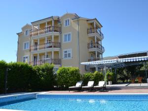 um edifício com duas cadeiras ao lado de uma piscina em Apartment Mare-3 by Interhome em Trogir