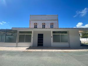 un edificio blanco con puertas abiertas en una calle en Gite 8 personnes - La Ronçoise, en La Tremblade