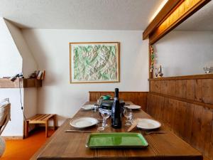 una mesa de madera con platos y vasos. en Apartment La Christaz-6 by Interhome, en Saint-Gervais-les-Bains