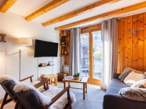 a living room with a couch and a tv at Apartment les Huskies by Interhome in Saint-Gervais-les-Bains