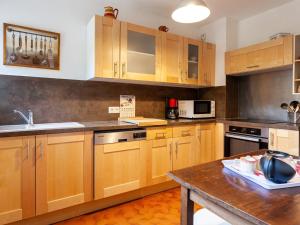 a kitchen with wooden cabinets and a wooden table at Apartment Le Diorama by Interhome in Saint-Gervais-les-Bains