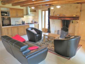ein Wohnzimmer mit 2 Ledersesseln und einem Kamin in der Unterkunft Holiday Home La Ferme by Interhome in Blanquefort-sur-Briolance