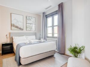 sypialnia z dużym białym łóżkiem i oknem w obiekcie limehome Madrid Calle de Don Ramón de la Cruz w Madrycie