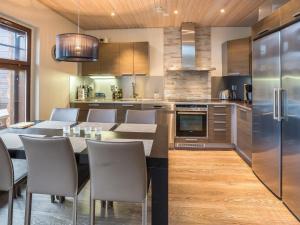 a kitchen with a table and chairs and a refrigerator at Holiday Home Karhunkieppi 9b- 2 skipasses included by Interhome in Levi
