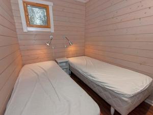 two beds in a small room with a window at Holiday Home Anttoora 4 by Interhome in Pori
