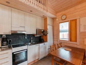 a kitchen with a wooden table and a wooden dining room at Holiday Home Anttoora 4 by Interhome in Pori