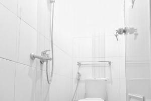 a white bathroom with a shower and a toilet at Paris Syariah Residence at Jalan Parangtritis Yogyakarta in Timuran