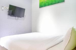 a bedroom with a bed with a tv on the wall at Paris Syariah Residence at Jalan Parangtritis Yogyakarta in Timuran +12 photos