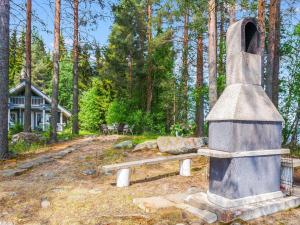 a stone monument with a bench in front of a house at Holiday Home Honkaniemi by Interhome in Hiukkajoki