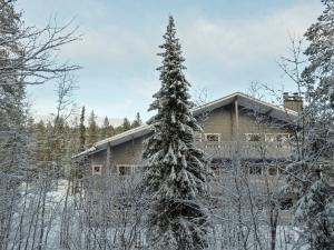 a house in the woods with a snow covered tree at Holiday Home Puolikuu a7 by Interhome in Sirkka