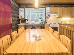 une cuisine avec une table en bois, des chaises et un comptoir dans l'établissement Holiday Home Rukanpesä 2b by Interhome, à Ruka