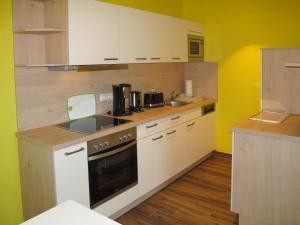a kitchen with white appliances and yellow walls at Apartment Altherscher Hof-2 by Interhome in Zarrentin