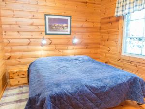 a bedroom with a bed in a wooden room at Holiday Home Tahkontupa by Interhome in Tahkovuori +11 photos