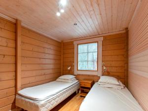 2 camas en una habitación con paredes de madera en Holiday Home Anttoora 2 by Interhome, en Pori