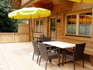 a table and chairs with an umbrella on a deck at Chalet Antonia-1 by Interhome in Finkenberg