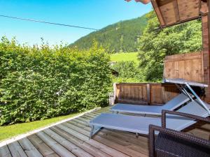 a wooden deck with two lounge chairs on it at Chalet Antonia-1 by Interhome in Finkenberg