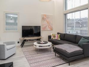 uma sala de estar com um sofá e uma televisão em Holiday Home Tonttutahko 20 a by Interhome em Tahkovuori