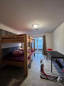 a room with two bunk beds and a desk at Fanky Guided Sport & Outdoor Experience - Hostel & Appartementhaus - Rafting&Canyoning in Haiming