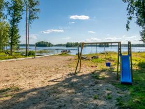 un parque infantil a orillas de un lago en Holiday Home Isokoskelo by Interhome, en Pertunmaa