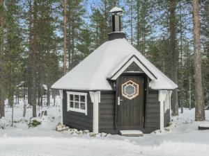 a small cabin with a snow covered roof in the snow at Holiday Home Rapsakka a by Interhome in Levi