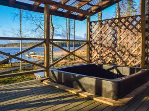 bañera en una terraza con vistas al agua en Holiday Home Isokoskelo by Interhome, en Pertunmaa