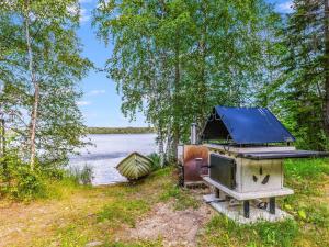 una estufa y un barco a orillas de un lago en Holiday Home Kiviniemi by Interhome, en Hiukkajoki